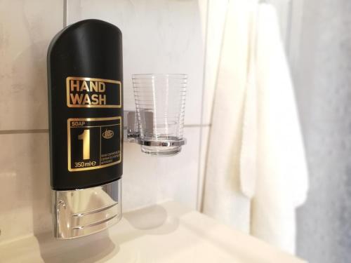 a bottle of hand wash sitting on a counter next to a glass at Ködnitzhof in Kals am Großglockner