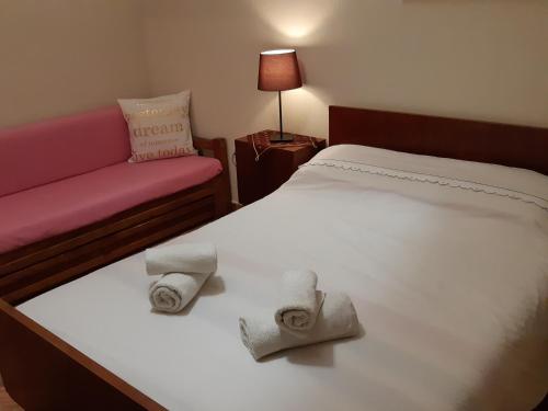 a hotel room with a bed and a couch and towels at Smart Choice Home in Néon Rýsion