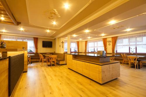 ein Restaurant mit einer Bar sowie Tischen und Stühlen in der Unterkunft Pension & Residence Astoria in Prad am Stilfserjoch