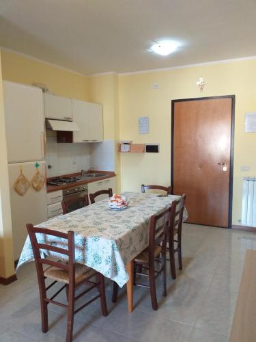 een keuken met een tafel en een aantal stoelen en een tafel en een kamer bij Casa Vacanze "Ai piedi di Assisi" in Bastia Umbra