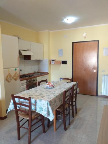 a kitchen with a table and some chairs and a table and a room at Casa Vacanze "Ai piedi di Assisi" in Bastia Umbra
