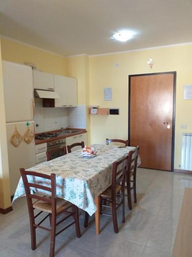 uma cozinha com uma mesa e algumas cadeiras e uma mesa e um quarto em Casa Vacanze "Ai piedi di Assisi" em Bastia Umbra
