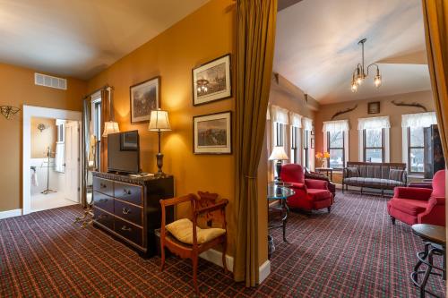 a living room with yellow walls and red furniture at Steele Mansion Inn & Gathering Hub in Painesville
