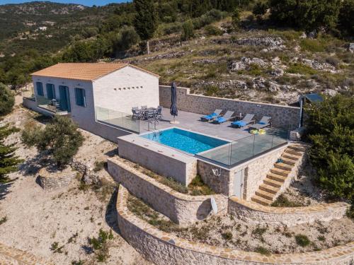 een luchtzicht op een huis met een zwembad bij Kampaki Stone Houses in Ayios Nikitas