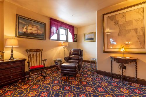 a living room with a chair and a desk at Steele Mansion Inn & Gathering Hub in Painesville