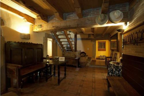 Posada Real La Vieja Chimenea-Spa في Herreros: غرفة معيشة كبيرة مع طاولة وغرفة بها