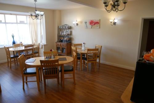 The Monsell Hotel في سكيجنيس: غرفة طعام مع طاولات وكراسي خشبية