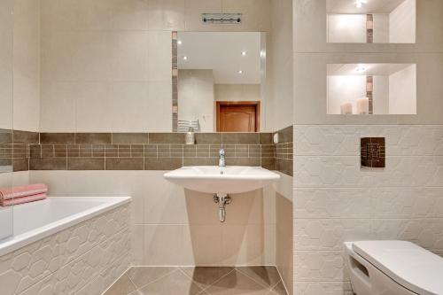 a bathroom with a sink and a toilet and a mirror at Apartament Sopot in Sopot