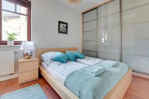 a bedroom with a large bed with blue pillows at Apartament Sopot in Sopot
