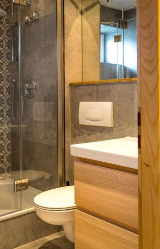 a bathroom with a toilet and a sink and a shower at Das Nordberg Guesthouse in Garmisch-Partenkirchen