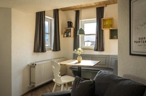 a small living room with a table and a chair at Das Nordberg Guesthouse in Garmisch-Partenkirchen