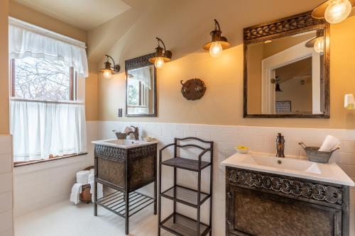 a bathroom with a sink and a mirror at Steele Mansion Inn & Gathering Hub in Painesville
