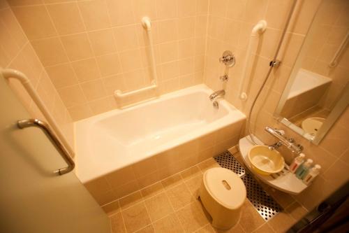 a bathroom with a white tub and a toilet at Hotel Grand Arc Hanzomon in Tokyo