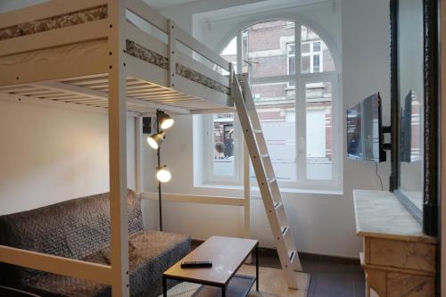 ein Hochbett in einem Zimmer mit einem Sofa und einem Schreibtisch in der Unterkunft Cosy Appartement proche Gares #1 in Lille