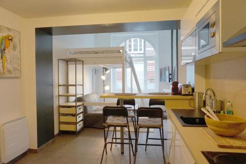 une cuisine avec un comptoir et des tabourets dans une pièce dans l'établissement Cosy Appartement proche Gares #1, à Lille