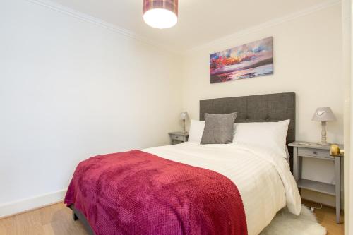 a bedroom with a large bed with a red blanket at Charming Apartment in the Old Town in Edinburgh