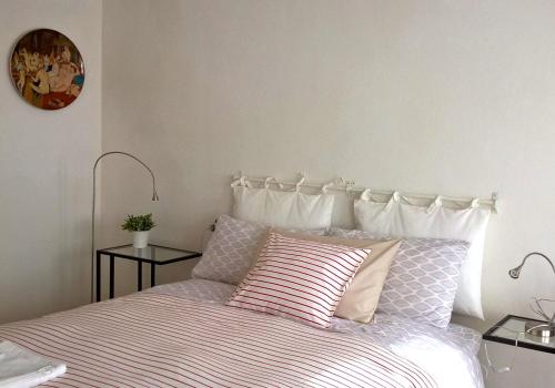 a bedroom with a bed with two pillows and a clock at Casa Il Gelsomino in Bologna
