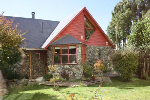 una casa con techo rojo y patio en Salamandra Apartamentos en El Calafate