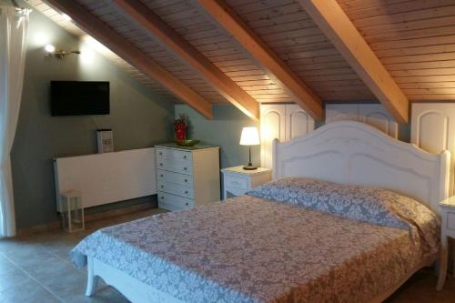 a bedroom with a white bed and a tv at Margarita's Attic-The Suite Loft in Spartia
