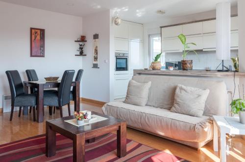 un soggiorno con divano e tavolo di Modern and bright apartment in Ruma a Ruma