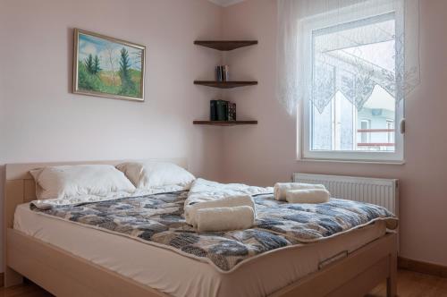 un letto con due cuscini sopra in una stanza con finestra di Modern and bright apartment in Ruma a Ruma
