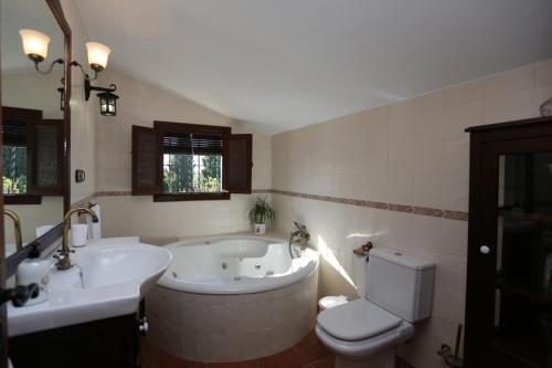 a bathroom with a tub and a toilet and a sink at Albara in Conil de la Frontera