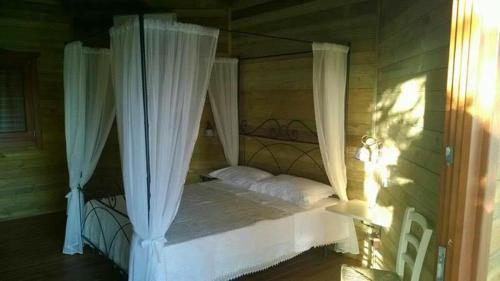 San Biagio Platani的住宿－El Bait，卧室配有带白色窗帘的天蓬床
