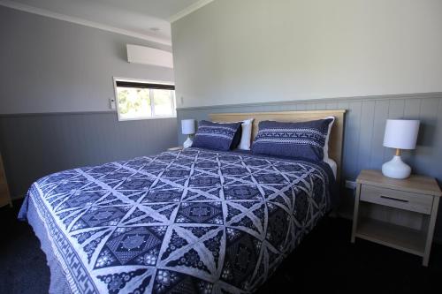 a bedroom with a bed with a blue and white comforter at Brecon Pond Bed & Breakfast in Stratford