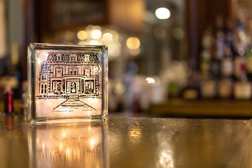 a glass cup with a picture of a building on a table at Steele Mansion Inn & Gathering Hub in Painesville