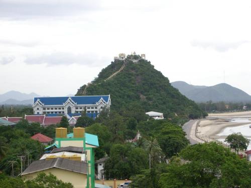 a house on a hill next to a beach at Hadthong Hotel in Prachuap Khiri Khan