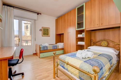 a bedroom with a bed and a desk and a table at My Malcesine Family Home XL in Malcesine