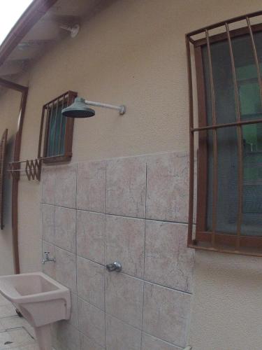a bathroom with a toilet and a sink on the wall at Chalés Beto Amá in Ubatuba