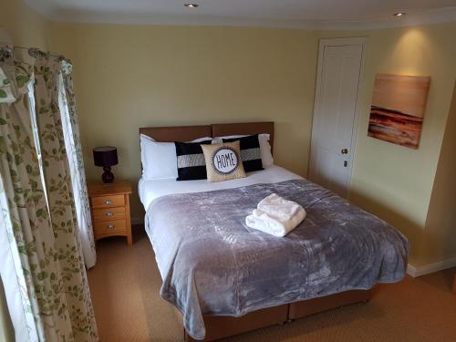 a bedroom with a bed with two towels on it at Slough Centre Townhouse with driveway parking for up to two cars in Slough