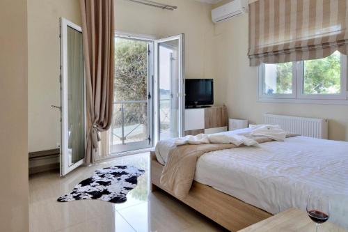 a bedroom with a bed and a large window at Katoi Apartment 2 Agios Georgios Pagoi in Agios Georgios Pagon