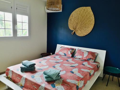 - une chambre avec un lit et un mur bleu dans l'établissement Ciel de Kaz, à Rivière-Salée