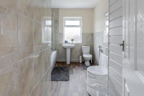 a bathroom with a toilet and a sink at Alphalite Homes in Barking