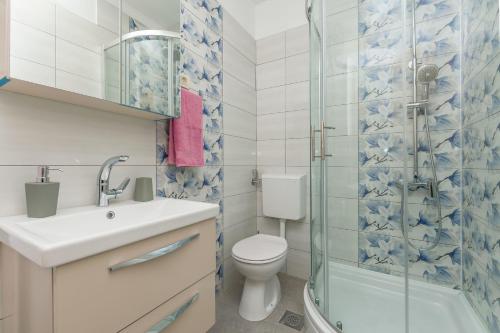a bathroom with a toilet and a glass shower at Apartment Ivano in Dugi Rat