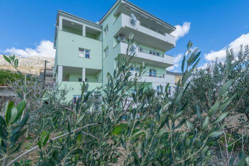 een wit gebouw achter wat planten bij Apartment Ivano in Dugi Rat