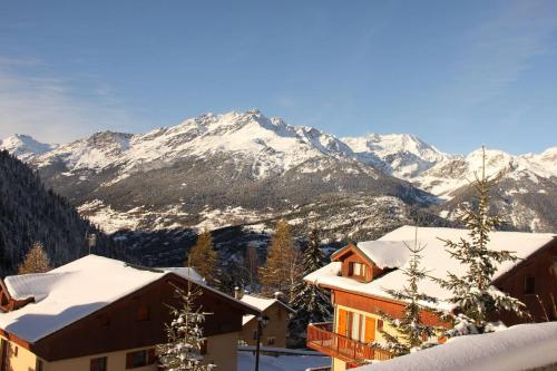 a snow covered mountain with houses and snow covered roofs at Appartement Ski Pied de Pistes - Valfréjus in Modane