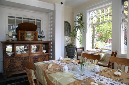 a dining room with a table and chairs and windows at Beaconsfield Bed and Breakfast - Victoria in Victoria