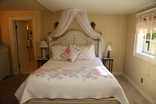 a bedroom with a large bed with a canopy at Beaconsfield Bed and Breakfast - Victoria in Victoria