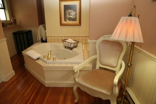 a bathroom with a tub and a chair and a lamp at Beaconsfield Bed and Breakfast - Victoria in Victoria