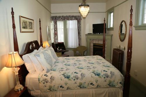a bedroom with a bed and a fireplace in it at Beaconsfield Bed and Breakfast - Victoria in Victoria