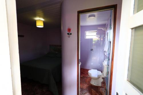 a bathroom with a toilet and a table in a room at Pousada Trilha Violeta in Sao Jorge