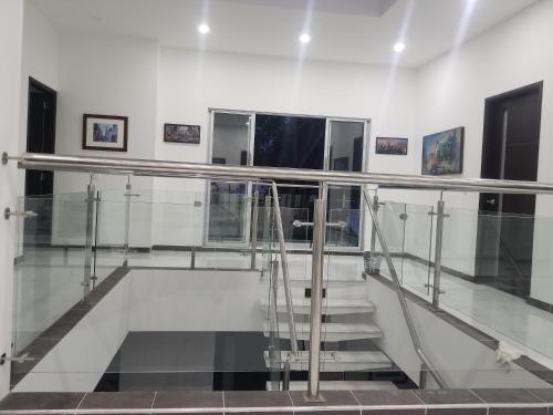 a staircase in a white room with glass railing at Casa Quinta Santana in Melgar