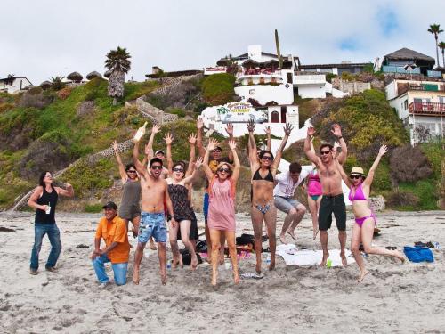 Eine Gruppe von Leuten, die am Strand springen in der Unterkunft Poco Cielo Hotel in Rosarito