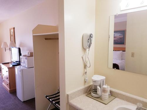 a bathroom with a phone in a hotel room at Canada's Best Value Desert Inn & Suites in Cache Creek