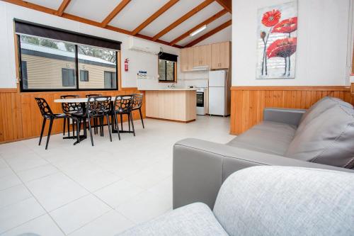 a living room with a couch and a table with chairs at BIG4 Renmark Riverfront Holiday Park in Renmark