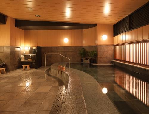 a swimming pool in a building with a swimming pool at Nishitetsu Inn Kurosaki in Kitakyushu