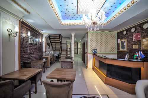 a restaurant with wooden tables and chairs and a chandelier at istanbul duhok hotel in Istanbul